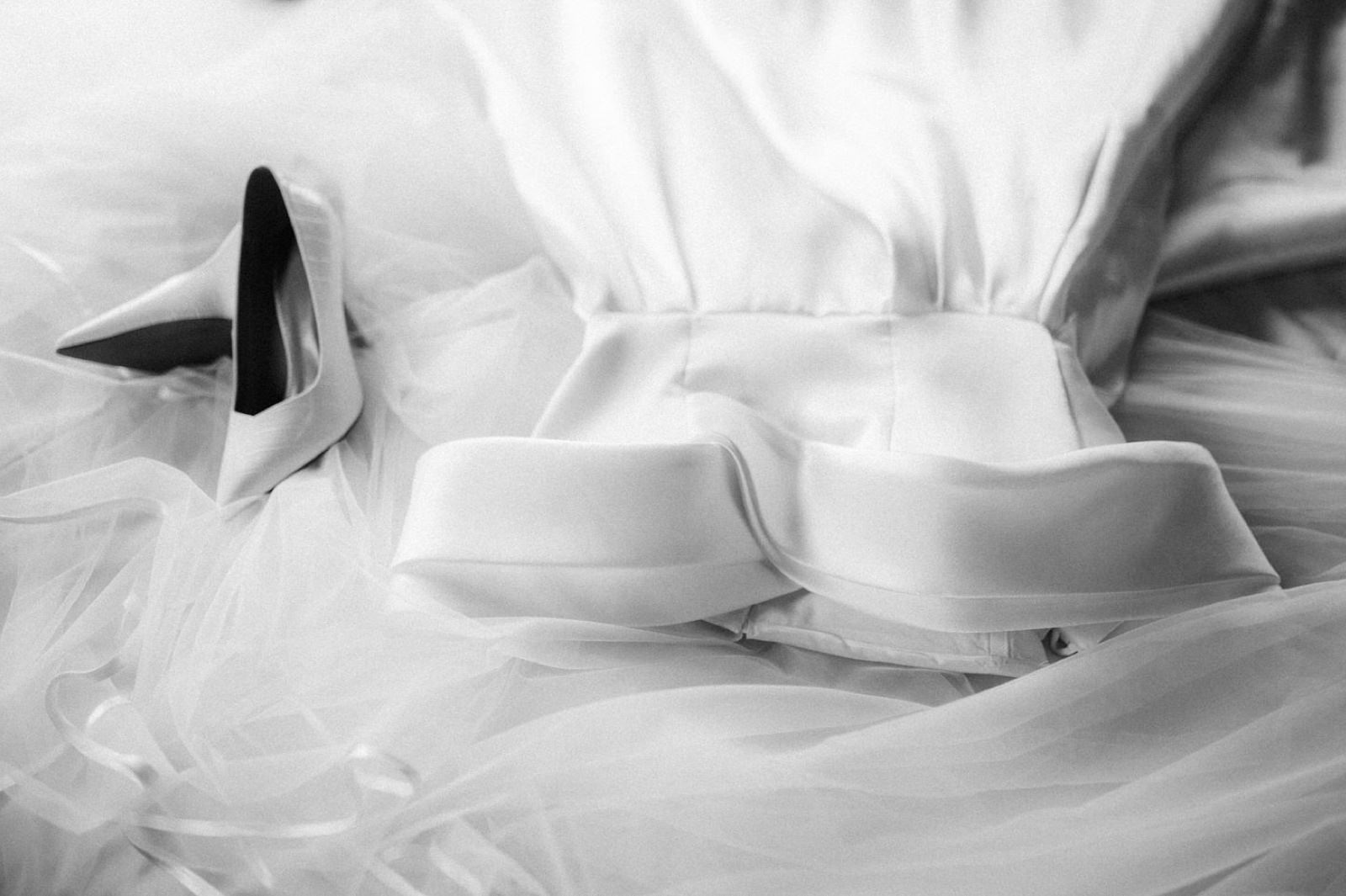 wedding dress and wedding shoes spread on the bed in room in San Canzian hotel in Croatia