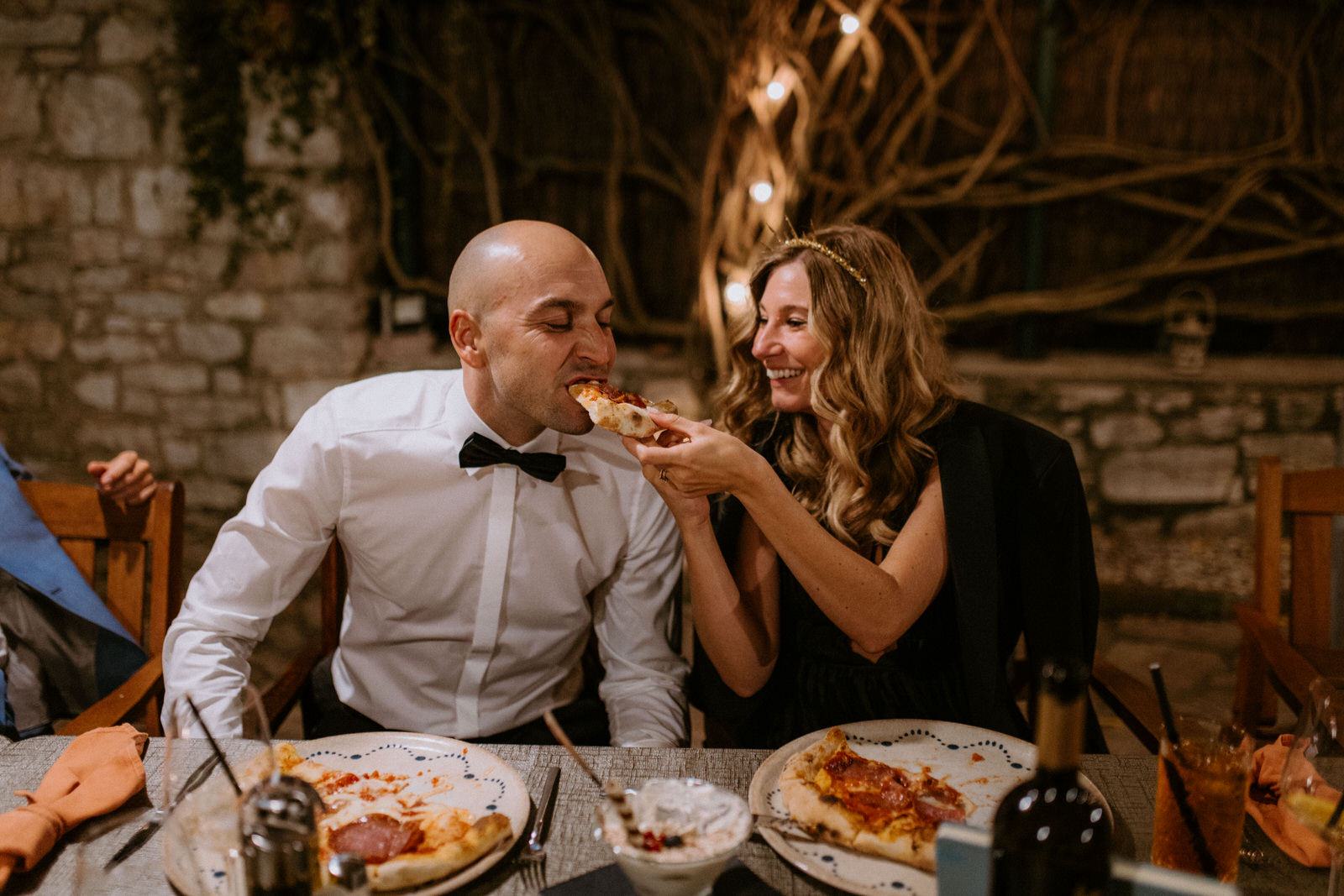 bride and groom eating pizza