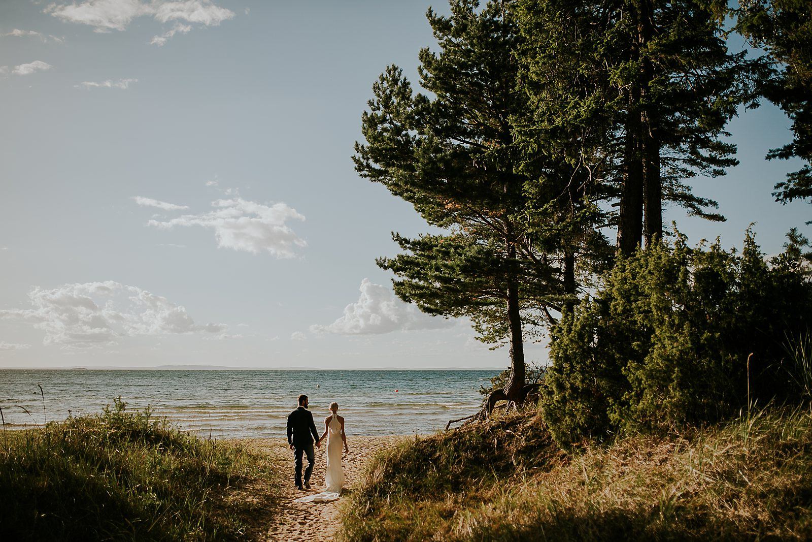 bride and groom walking on the beach of lake Vattern, Sweden