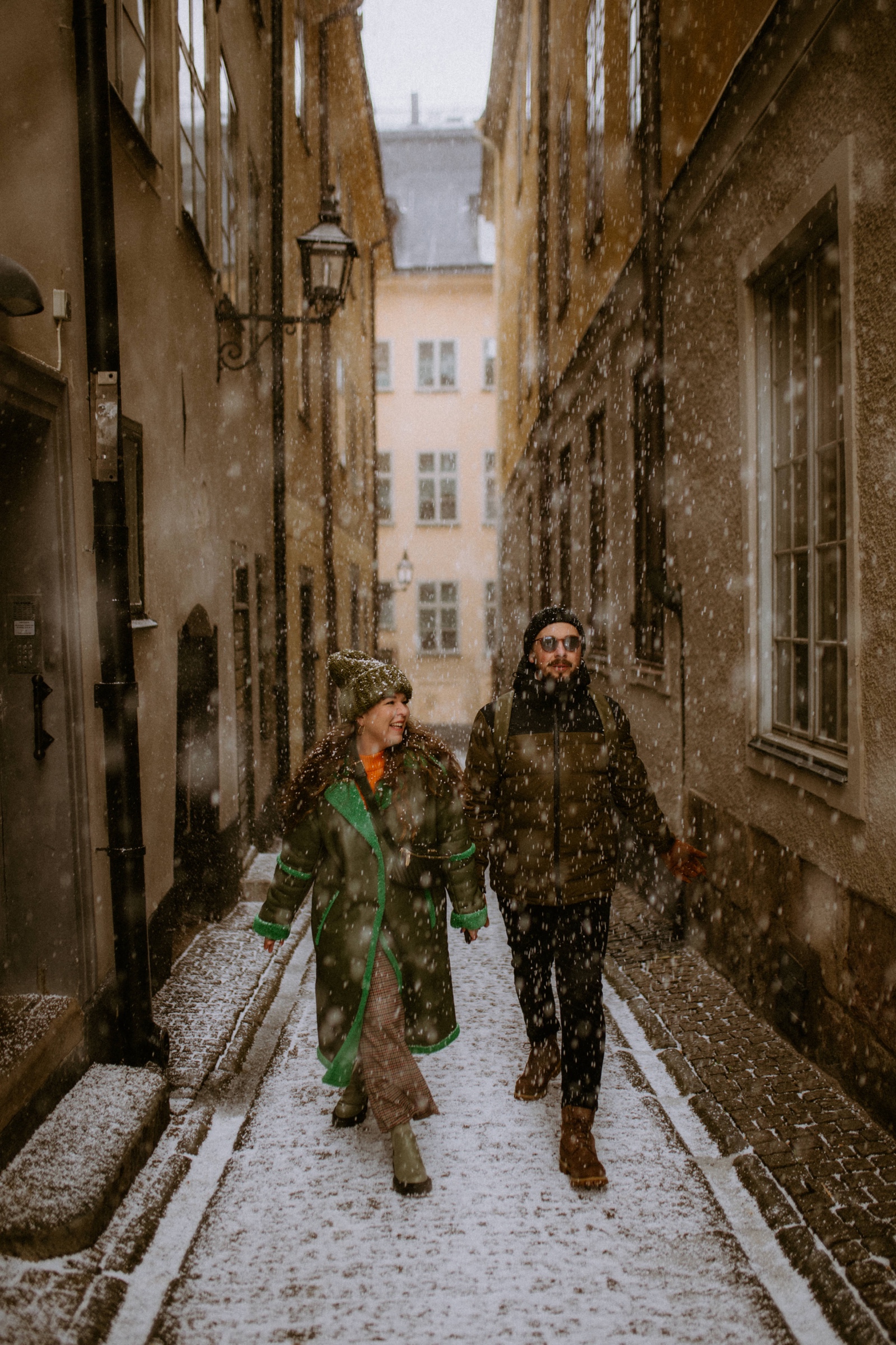 couple walking in the snow in Gamla stan Stockholm