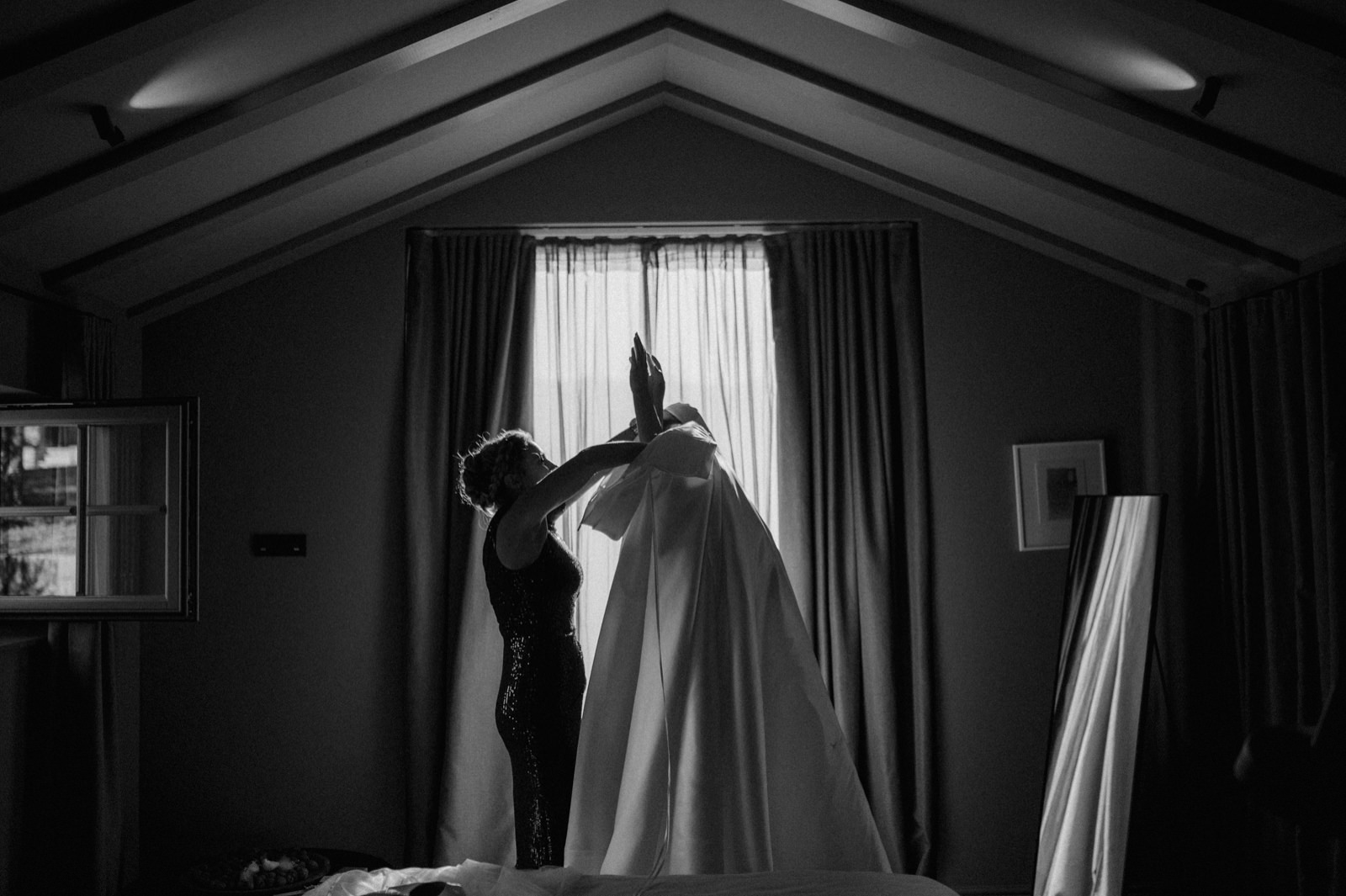 bride getting her dress on with help of her maid of honor