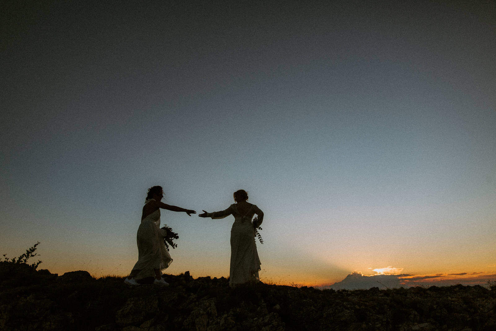 silhouette of two brides walking on top of the mountain in Croatia