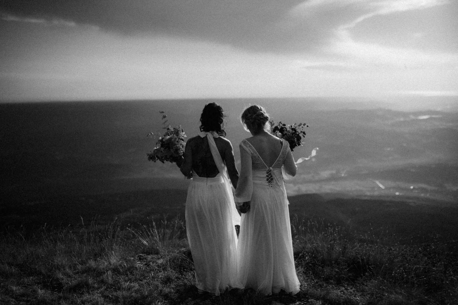 two brides on top of mountain Ucka in Croatia holding hands